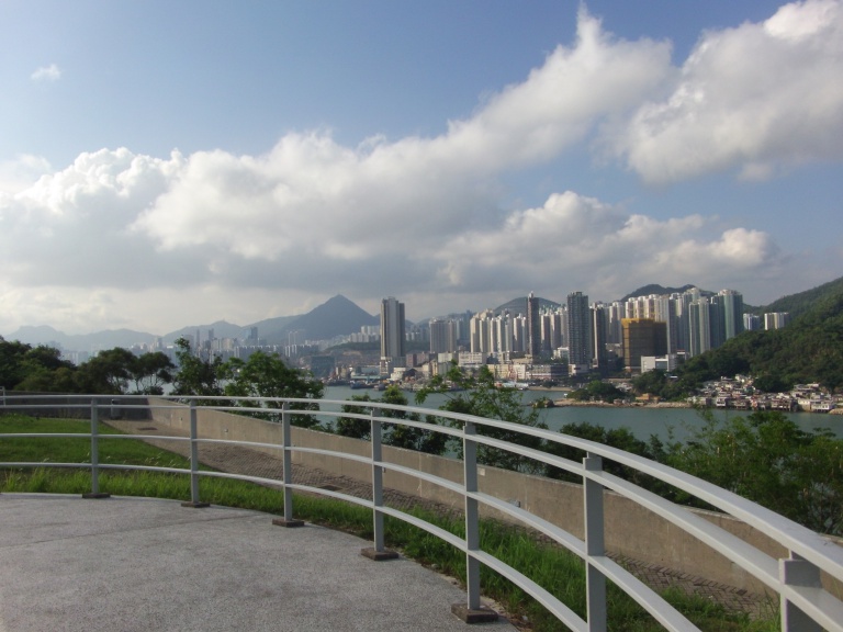 fence, sea view, tall buildings, mountain, blue sky with cloud